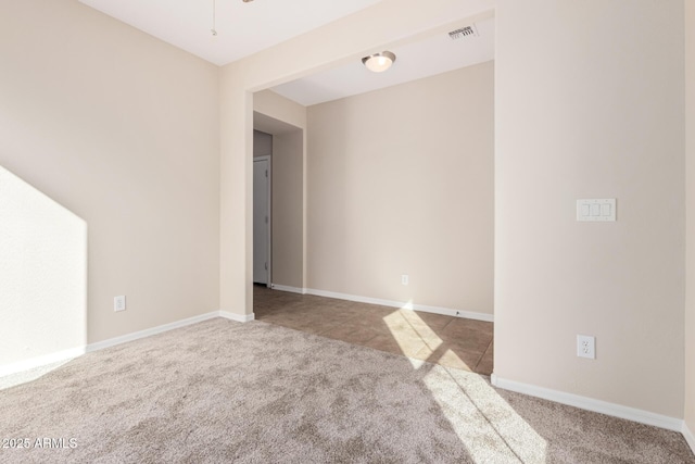 unfurnished room with baseboards, visible vents, and carpet flooring