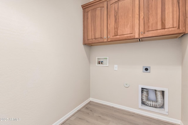 laundry area with hookup for an electric dryer, washer hookup, baseboards, light wood-style floors, and cabinet space