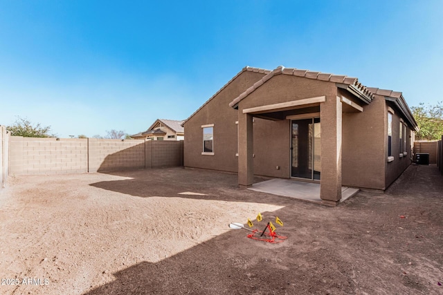 back of house featuring a patio area, a fenced backyard, a tiled roof, and stucco siding