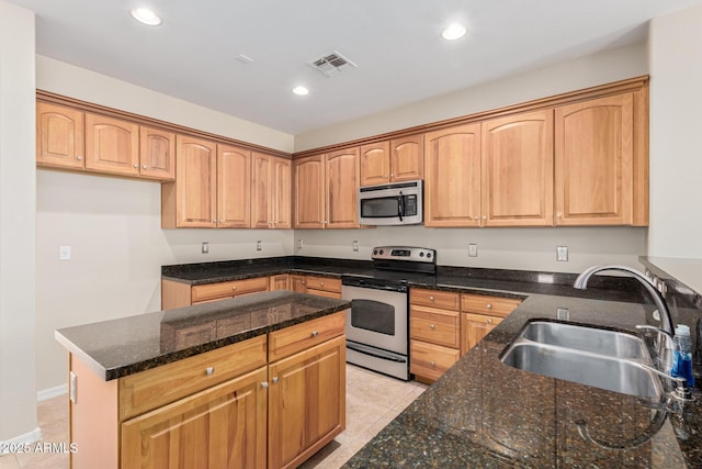 kitchen with light tile patterned floors, a sink, visible vents, appliances with stainless steel finishes, and dark stone countertops