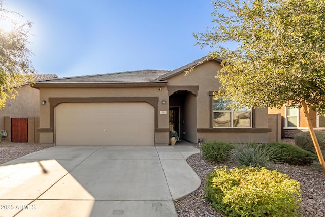 mediterranean / spanish-style house with fence, a tiled roof, concrete driveway, stucco siding, and an attached garage