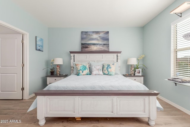 bedroom featuring baseboards and light wood finished floors