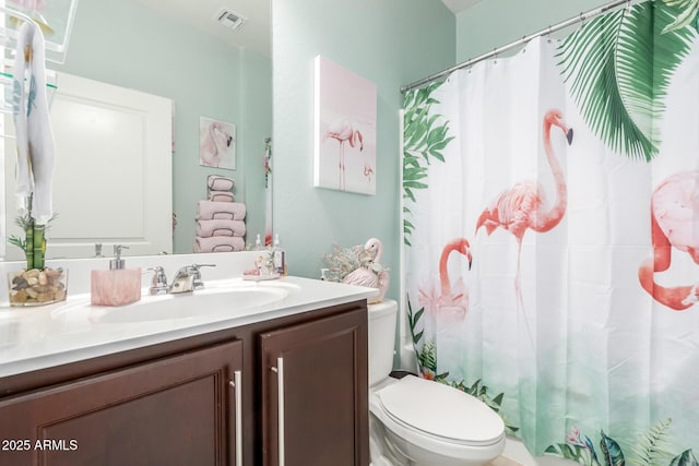 bathroom with a shower with shower curtain, vanity, and toilet