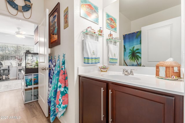 bathroom with hardwood / wood-style floors, ceiling fan, and vanity