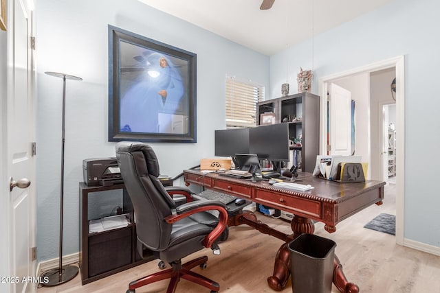 office with light wood-type flooring and ceiling fan