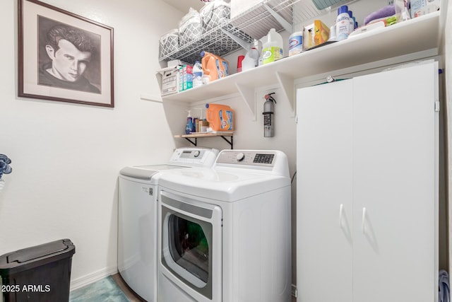 clothes washing area featuring laundry area, baseboards, and washer and clothes dryer