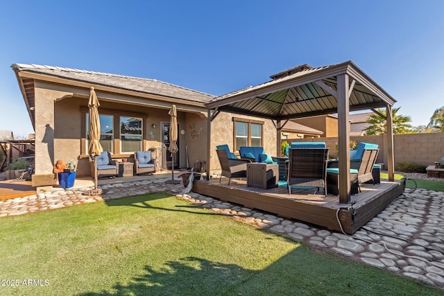 back of house with stucco siding, outdoor lounge area, a deck, and fence