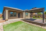 rear view of property featuring a gazebo, a patio, a yard, and fence