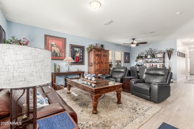 living room with light hardwood / wood-style flooring and ceiling fan