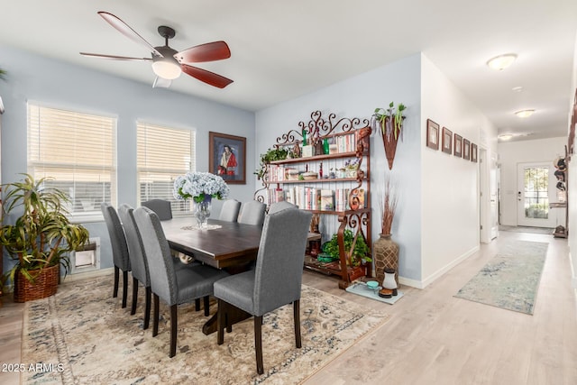 dining area with ceiling fan, baseboards, and wood finished floors