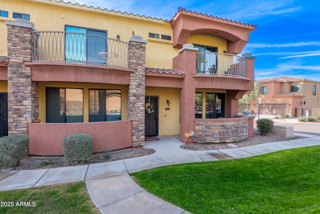 view of front of home with a balcony and a front lawn