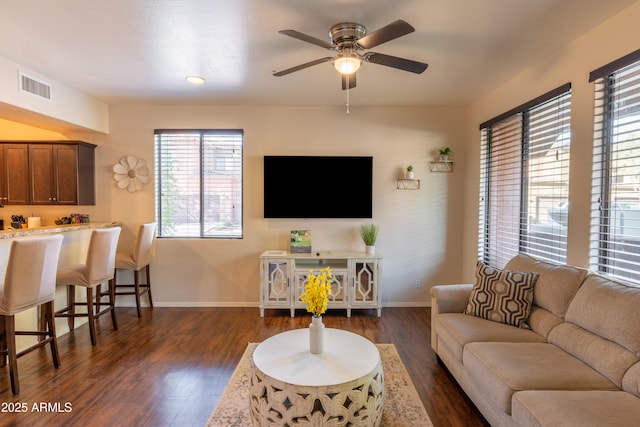 living room featuring ceiling fan and dark wood-type flooring