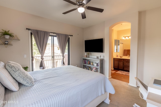 bedroom with access to exterior, light carpet, ensuite bathroom, and ceiling fan