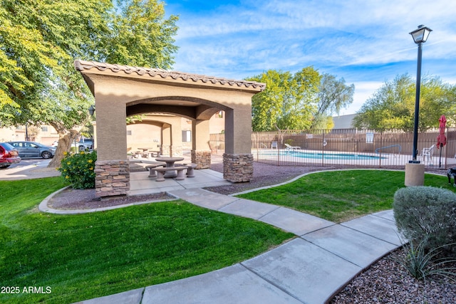 view of home's community featuring a patio area, a yard, and a pool