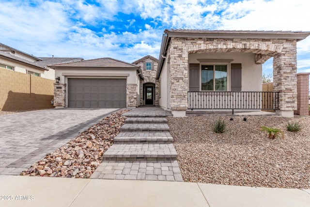 view of front of property with fence, stucco siding, a garage, stone siding, and decorative driveway