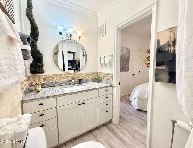 2150 W Missouri Ave Unit 120, Phoenix, AZ 85015 - bathroom with visible vents, wood finished floors, crown molding, vanity, and connected bathroom