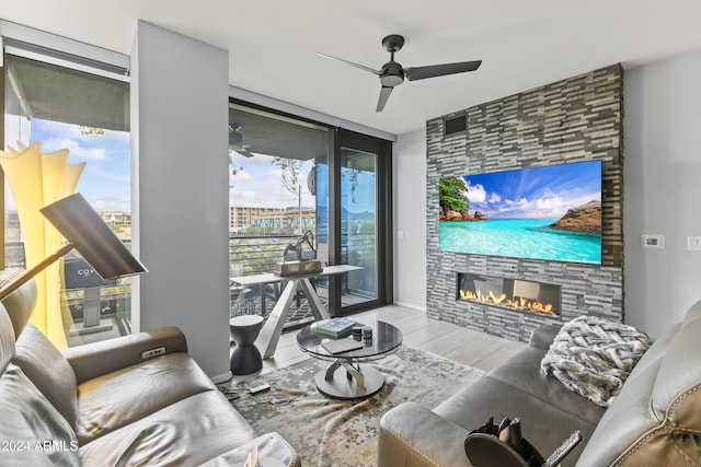 living room featuring hardwood / wood-style flooring, ceiling fan, expansive windows, and a fireplace