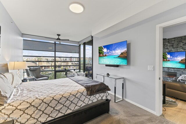 bedroom featuring a stone fireplace and carpet