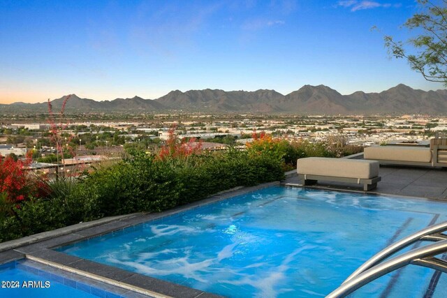 view of swimming pool with a mountain view