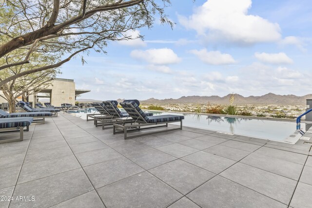 view of patio / terrace with a water and mountain view