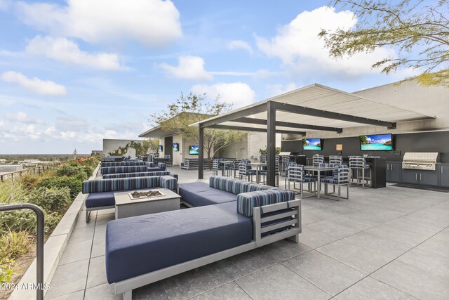 view of patio with an outdoor living space with a fire pit, grilling area, and exterior kitchen