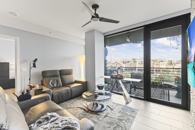 tiled living room with ceiling fan and floor to ceiling windows