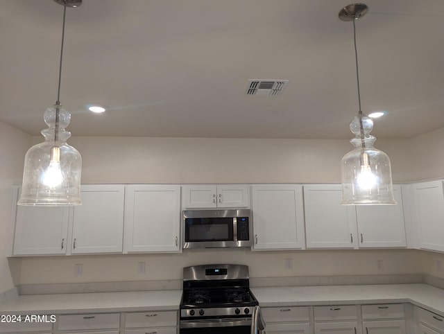 kitchen featuring white cabinetry, stainless steel appliances, and pendant lighting