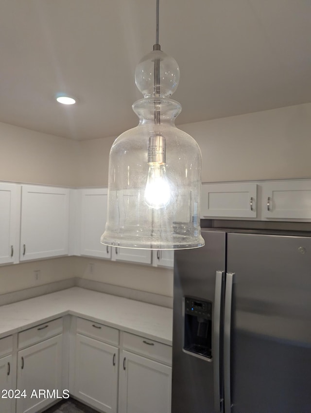 kitchen featuring white cabinets, pendant lighting, and stainless steel fridge with ice dispenser