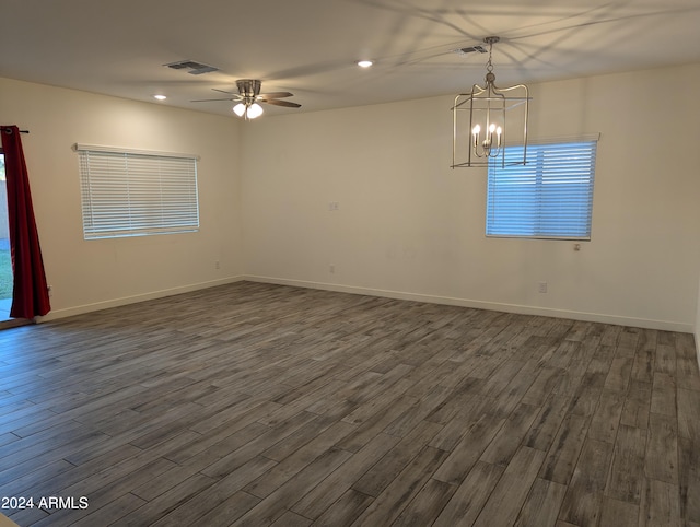 unfurnished room with dark hardwood / wood-style floors and ceiling fan with notable chandelier