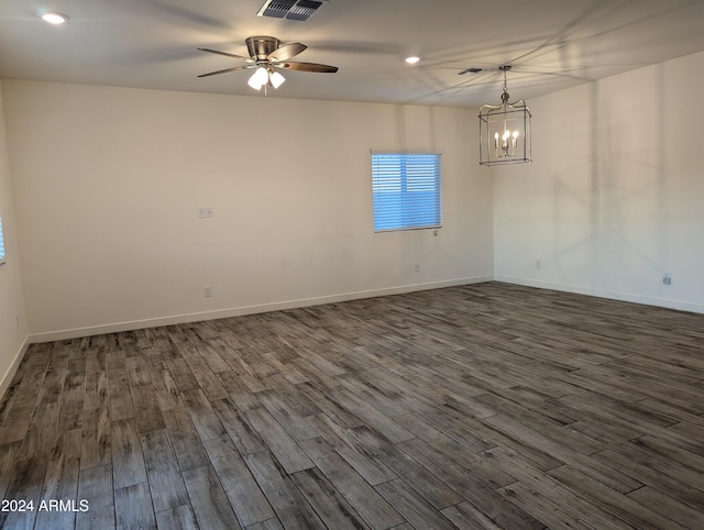 empty room featuring dark hardwood / wood-style flooring and ceiling fan with notable chandelier