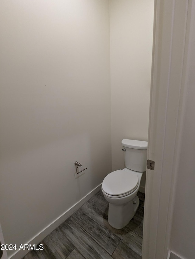 bathroom with toilet and hardwood / wood-style floors