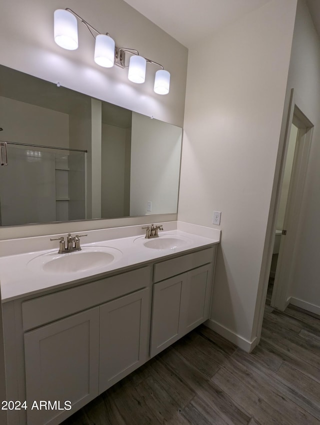 bathroom with vanity, walk in shower, and hardwood / wood-style flooring