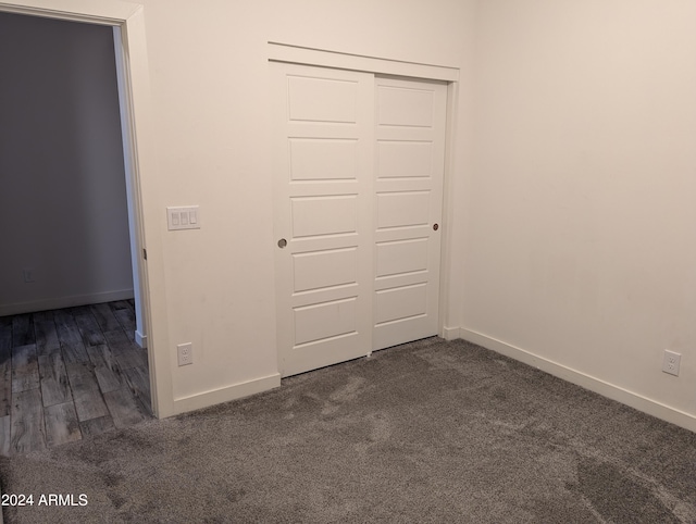 unfurnished bedroom with a closet and dark hardwood / wood-style flooring