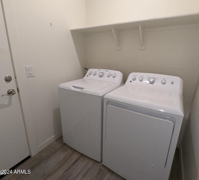 washroom with dark wood-type flooring and washer and clothes dryer