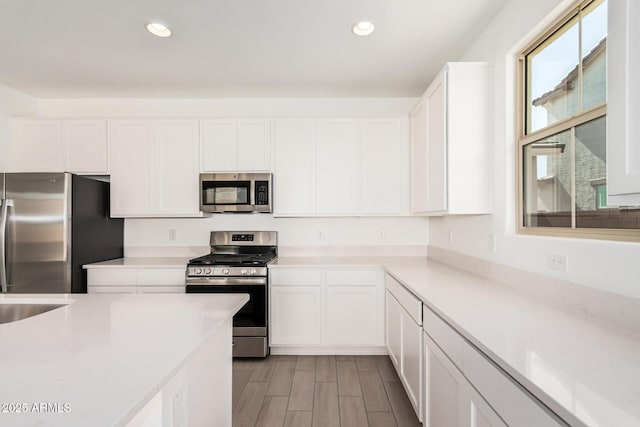 kitchen with white cabinets, stainless steel appliances, and light countertops