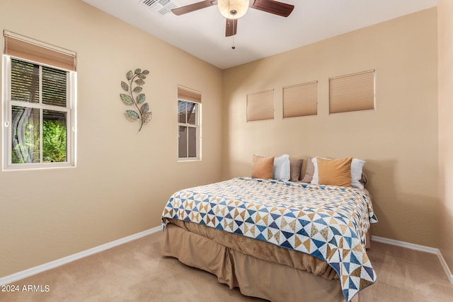 bedroom with ceiling fan and light carpet