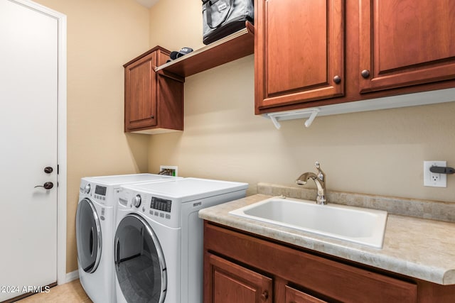 washroom featuring cabinets, washing machine and dryer, and sink