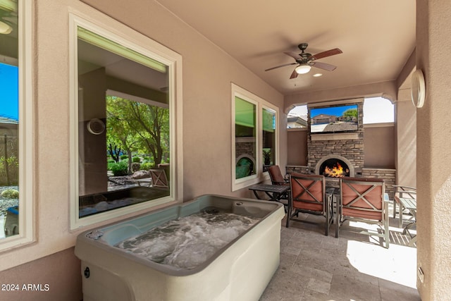 view of patio with an outdoor stone fireplace and ceiling fan