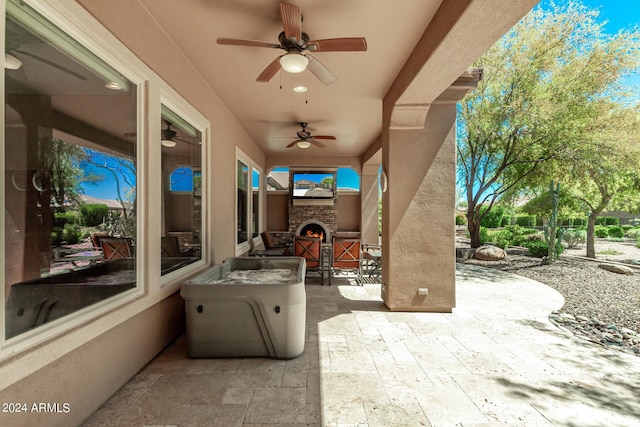 view of patio with an outdoor stone fireplace and ceiling fan