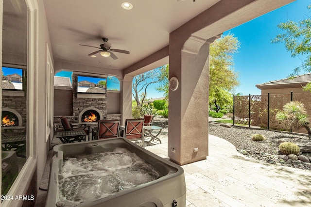 view of patio / terrace featuring an outdoor stone fireplace and ceiling fan