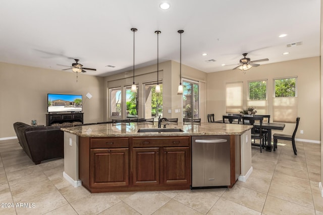 kitchen with decorative light fixtures, ceiling fan, and an island with sink