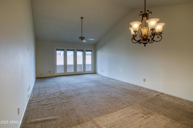 empty room with lofted ceiling, ceiling fan with notable chandelier, and carpet