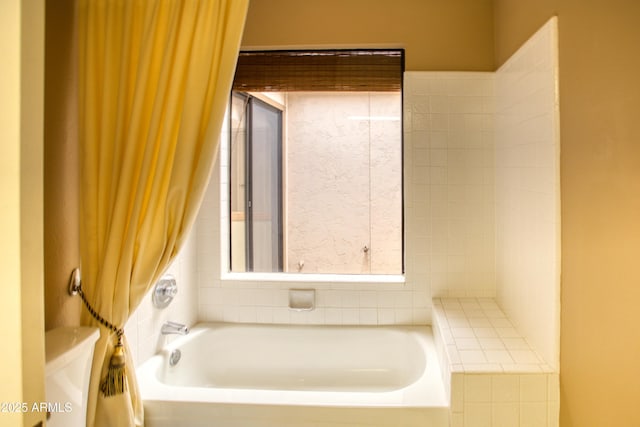 bathroom featuring shower with separate bathtub and toilet