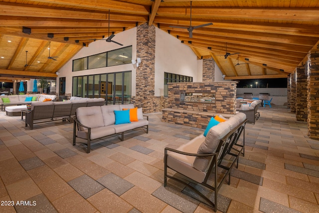 view of patio / terrace featuring ceiling fan and an outdoor living space with a fireplace