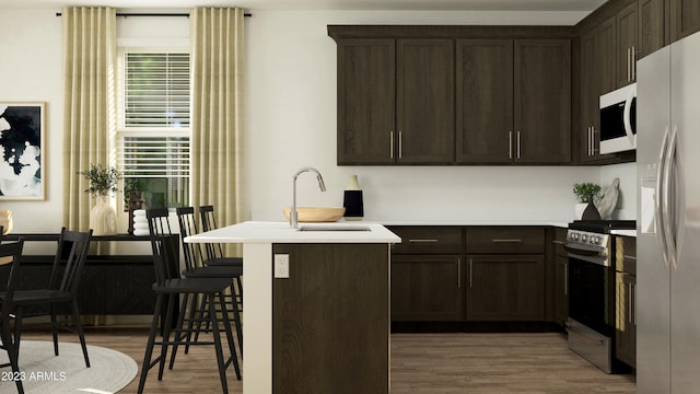 kitchen with sink, kitchen peninsula, a kitchen breakfast bar, stove, and dark wood-type flooring