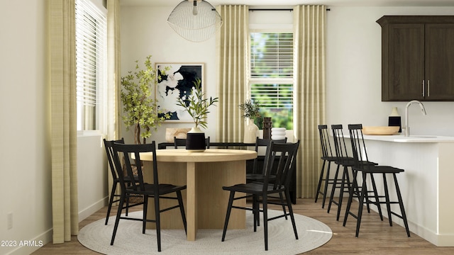 dining area with sink and light wood-type flooring