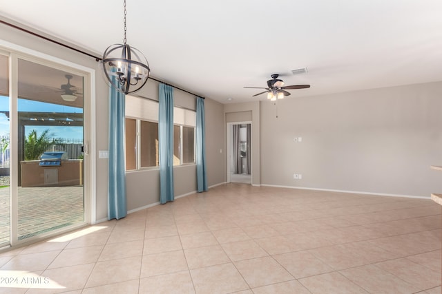 tiled empty room with ceiling fan with notable chandelier