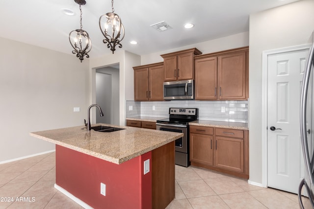 kitchen featuring sink, a chandelier, decorative light fixtures, a kitchen island with sink, and appliances with stainless steel finishes