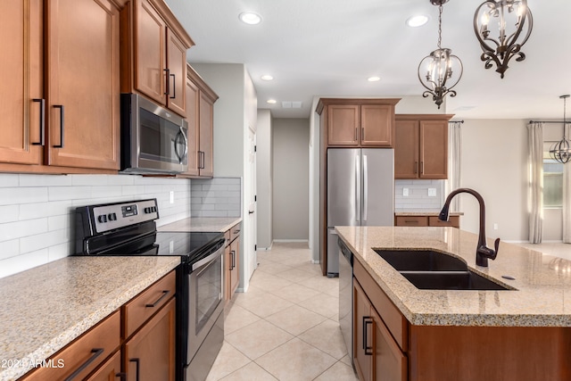 kitchen with sink, an inviting chandelier, decorative light fixtures, and appliances with stainless steel finishes