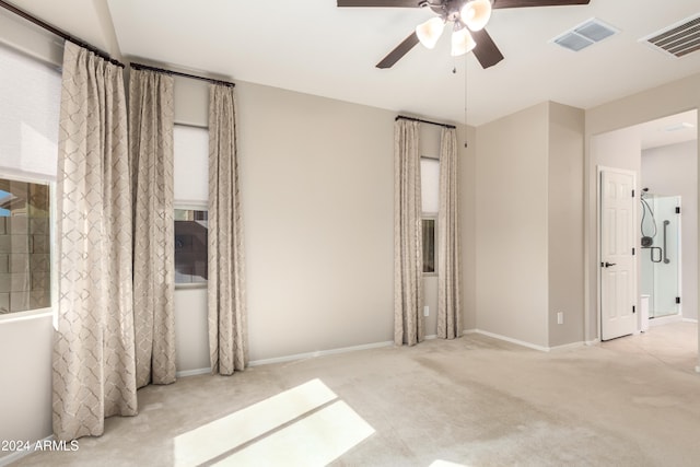 carpeted spare room featuring ceiling fan